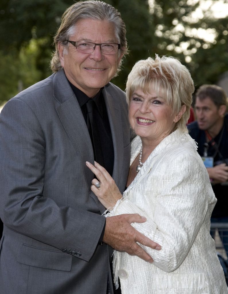 Gloria Hunniford in white hugging her husband Stephen Way
