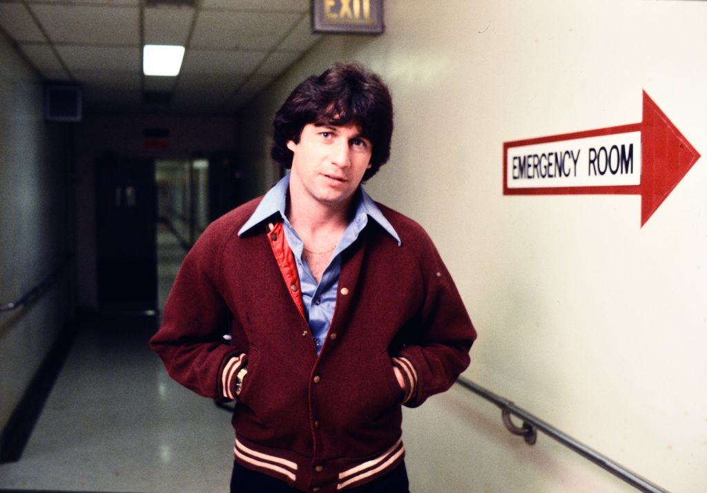 Joey Travolta posing in a burgundy varsity jacket