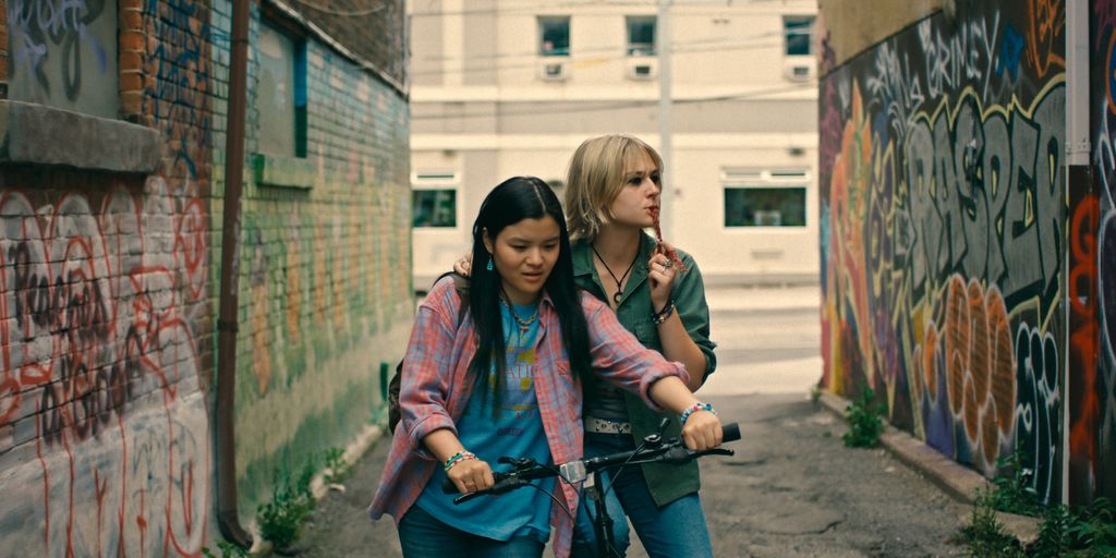 two teens pushing bike down alley