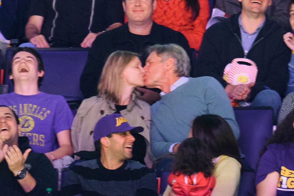 Calista Flockhart and Harrison Ford kiss at a basketball game between the Boston Celtics and the Los Angeles Lakers at Staples Center on February 22, 2015 in Los Angeles, California