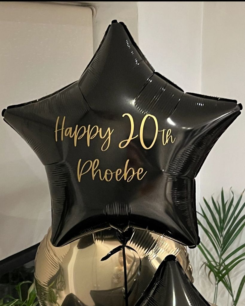 star-shaped balloon with gold writing