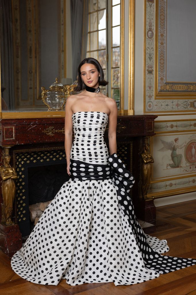 young lady in black and white polka dot gown