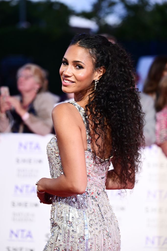 Vick Hope in an embellished white dress looking over her shoulder
