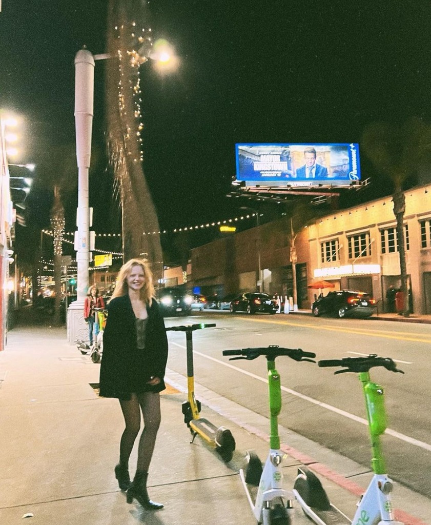 Emma Laird next to green scooters