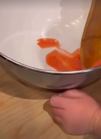 Princess Lilibet's hands with a bowl of jam and a wooden spoon