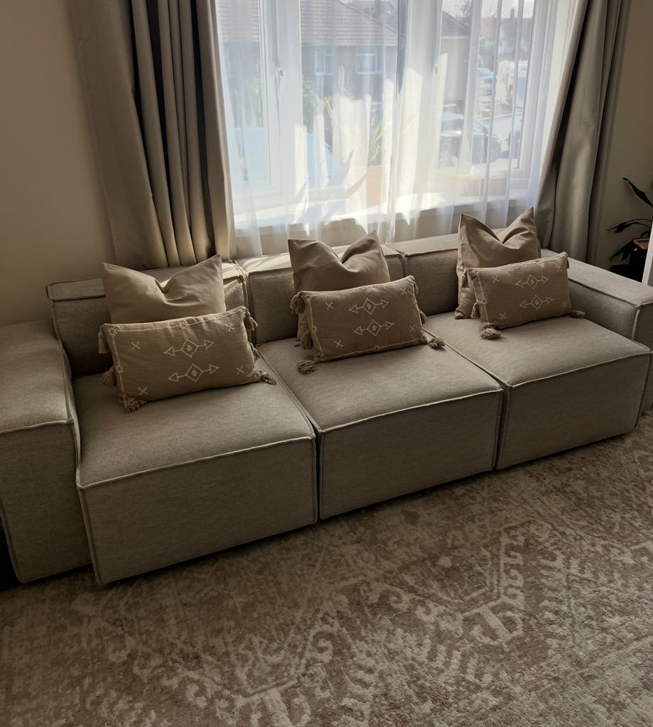 sofa with cushions in living room with rug on floor