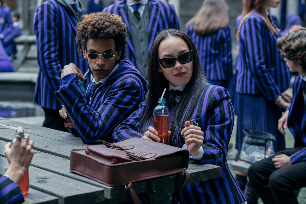 teen boy and girl sitting on bench in purple blazer