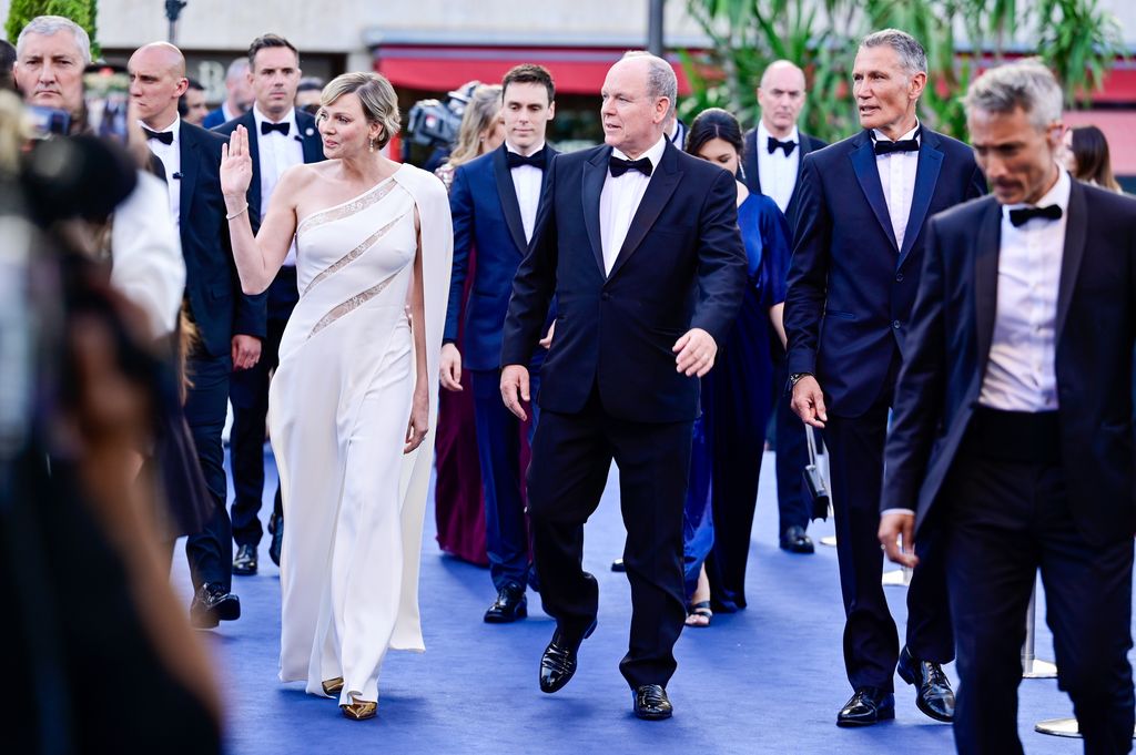 Albert II, Prince of Monaco and Charlene walking on blue carpet