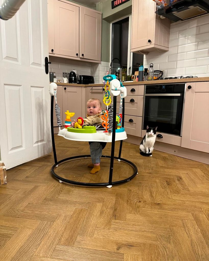 baby boy using walker in kitchen 
