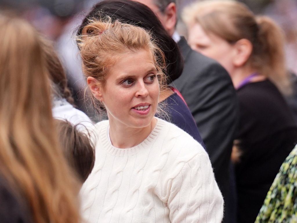 woman in white jumper standing in crowd