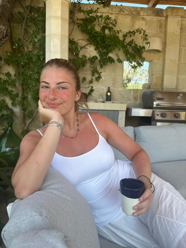 daisy oliver sitting in white outfit