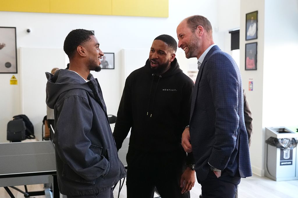 Prince William laughing while chatting to football player Reiss Nelson who is smiling