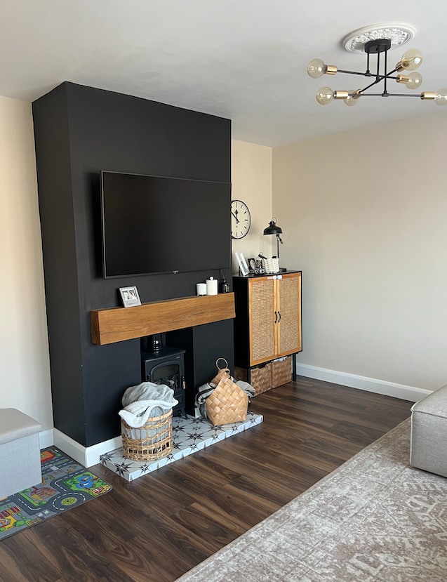 living room with dark flooring, black fire breast, rug and tv on wall