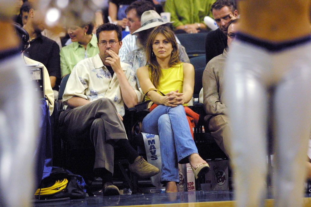 Mathew Perry and Elizabeth Hurley watch the San Antonio Spurs take on the Dallas Mavericks in game three of round two of the NBA playoffs at  Reunion Arena in Dallas, Texas.