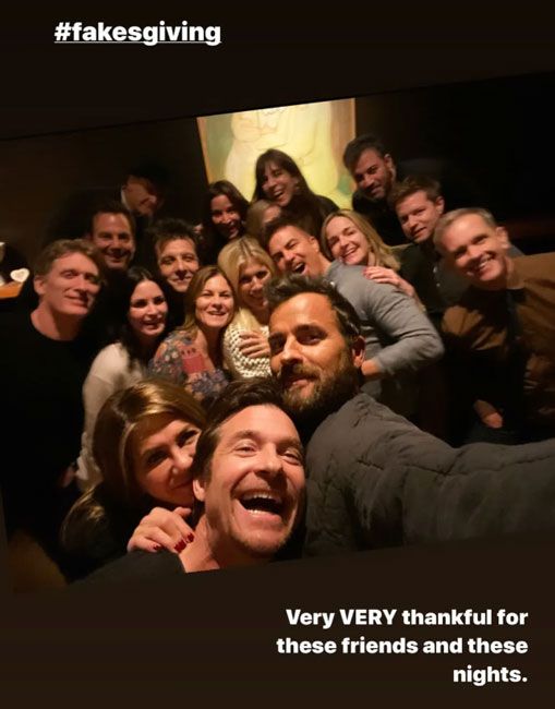 over a dozen celebrities gathered in a dark room for group selfie