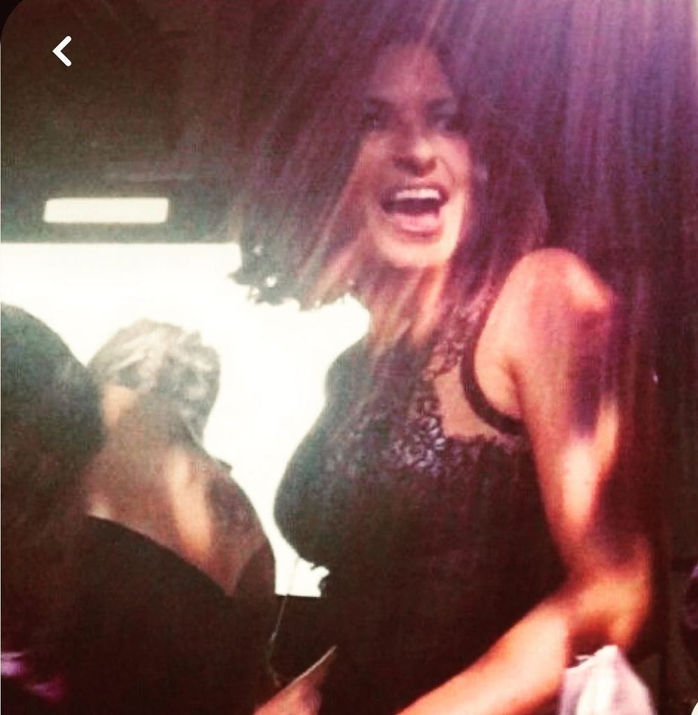 Mariska wearing a black lace dress as she smiles and dances
