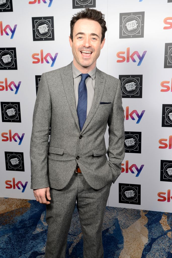 man in grey suit and blue tie