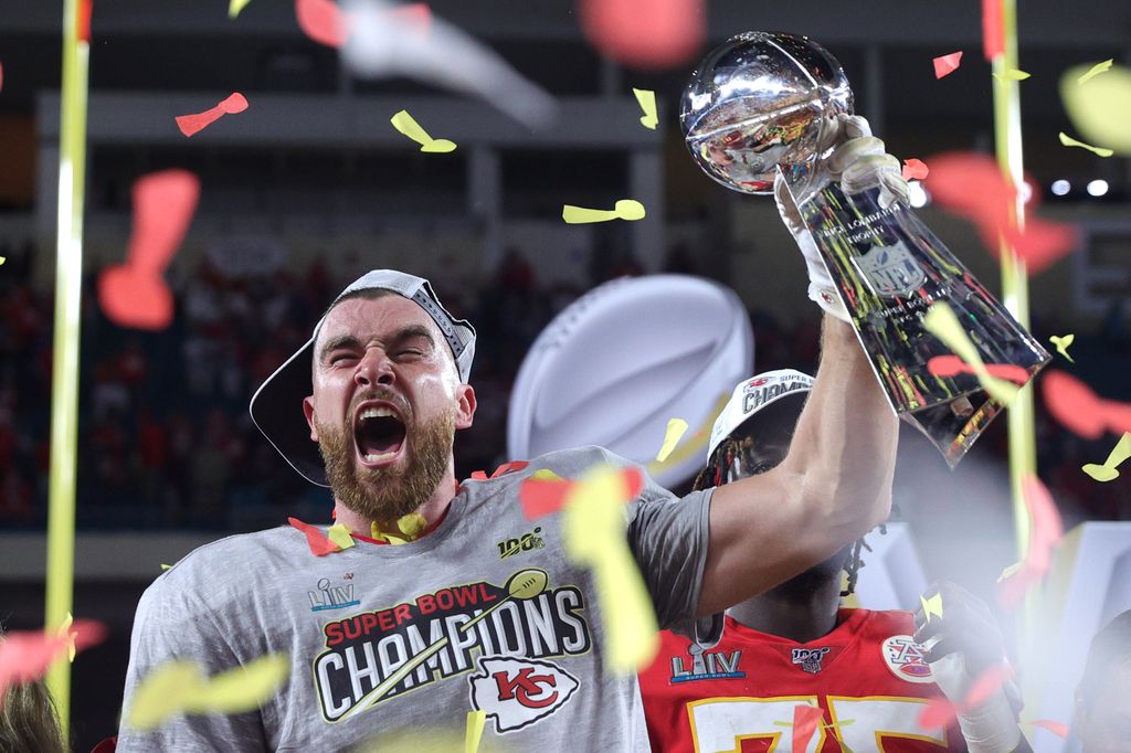 Travis Kelce #87 of the Kansas City Chiefs raises the Vince Lombardi Trophy after defeating the San Francisco 49ers 31-20 in Super Bowl LIV 