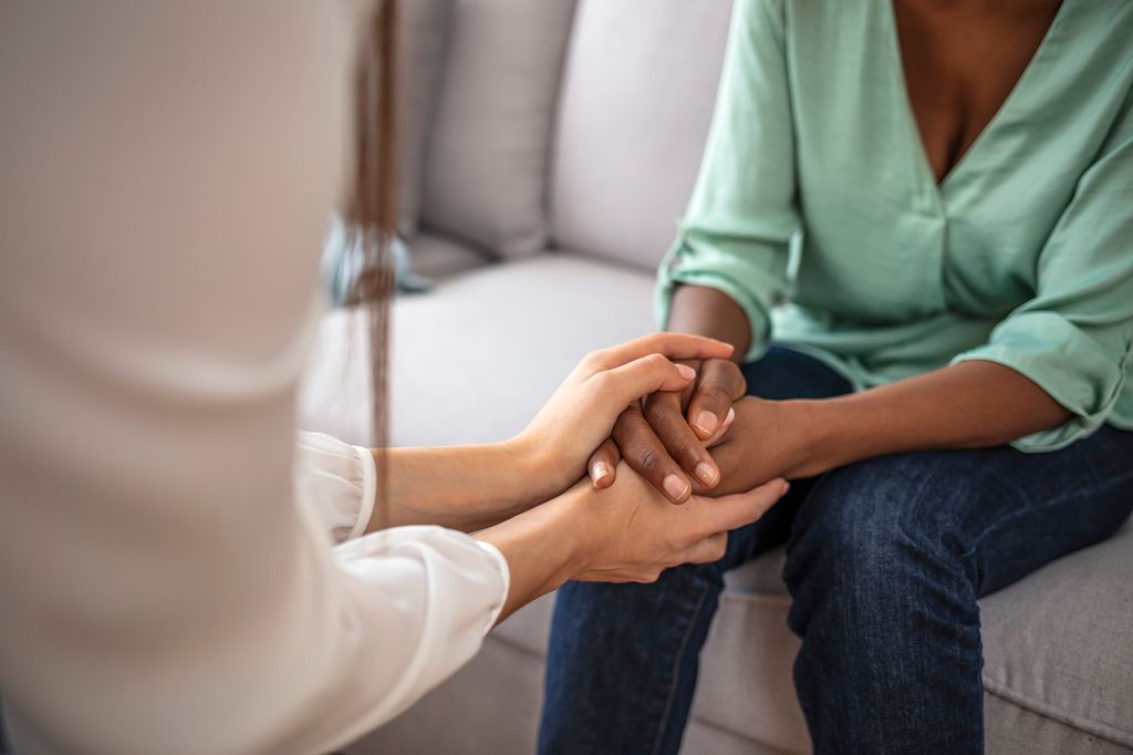 psychologist holding hands with patient