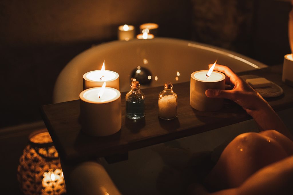 Woman relaxing in bathroom. Female pleasure and wellbeing, time to self. Cozy and quiet atmosphere. Copy space background with unrecognizable person.