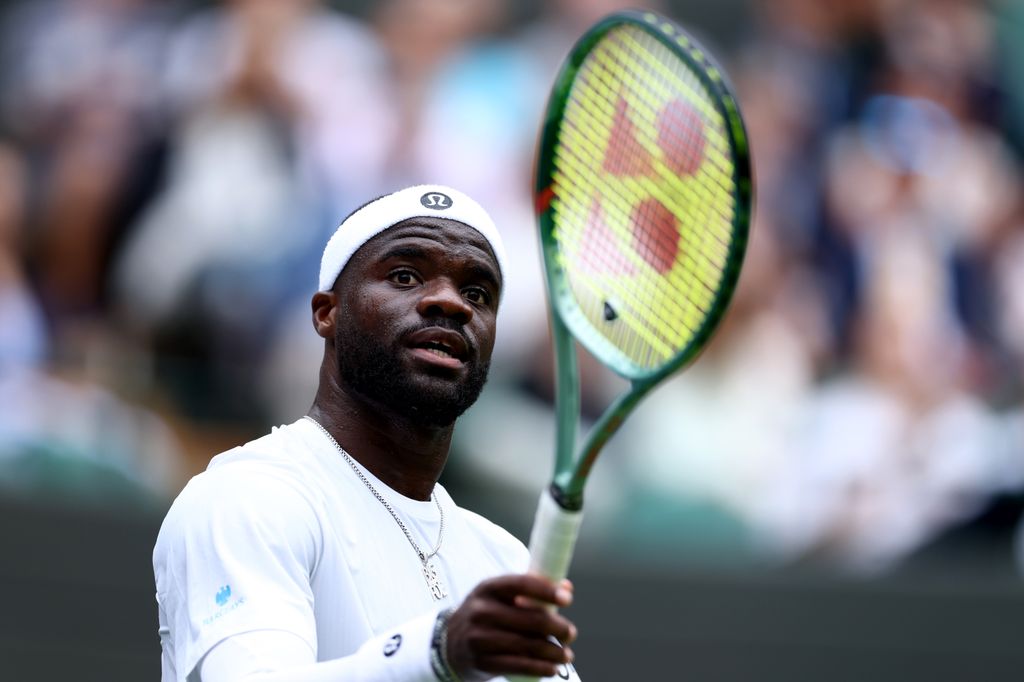 Frances Tiafoe holding a tennie racket