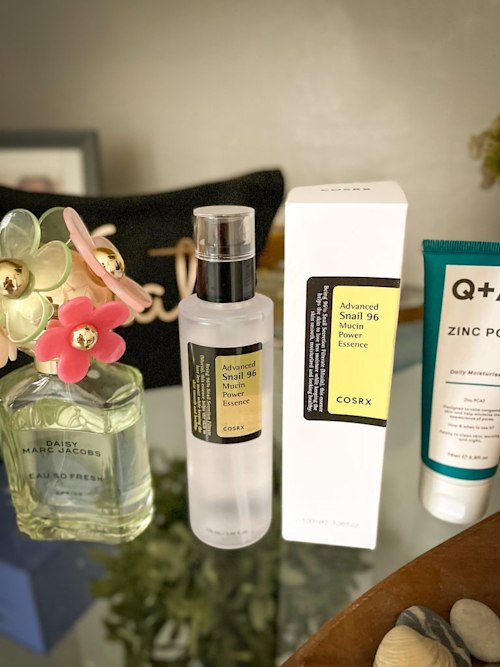 Snail mucin product on a bathroom shelf
