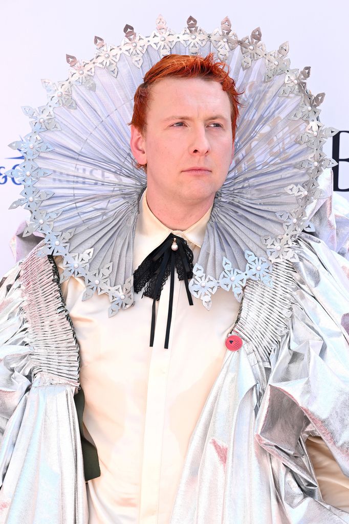 Joe Lycett in a white suit with an Elizabethean headdress