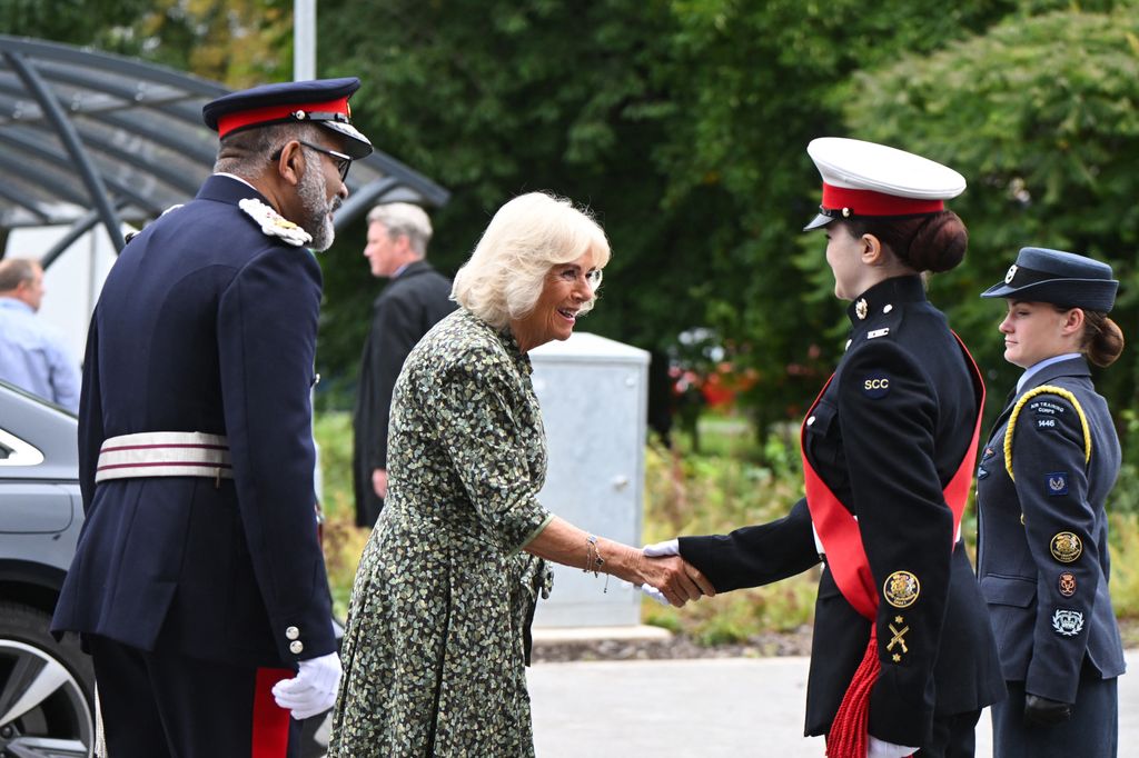 queen camilla shaking hands with someone