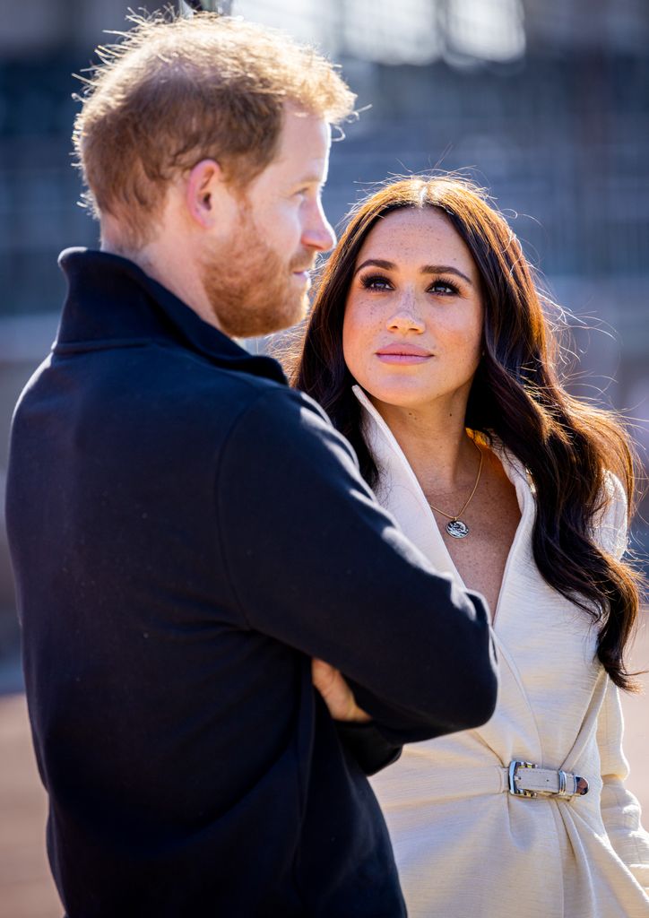 Meghan looking up at harry looking serious