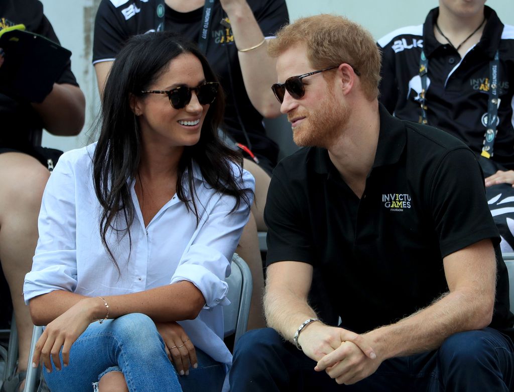 Prince Harry and Meghan Markle lean into each other at the 2017 Invictus Games in Toronto, Canada. 