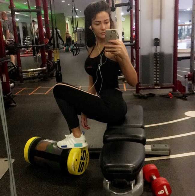 Michelle Keegan in the gym with her leg up on exercise equipment