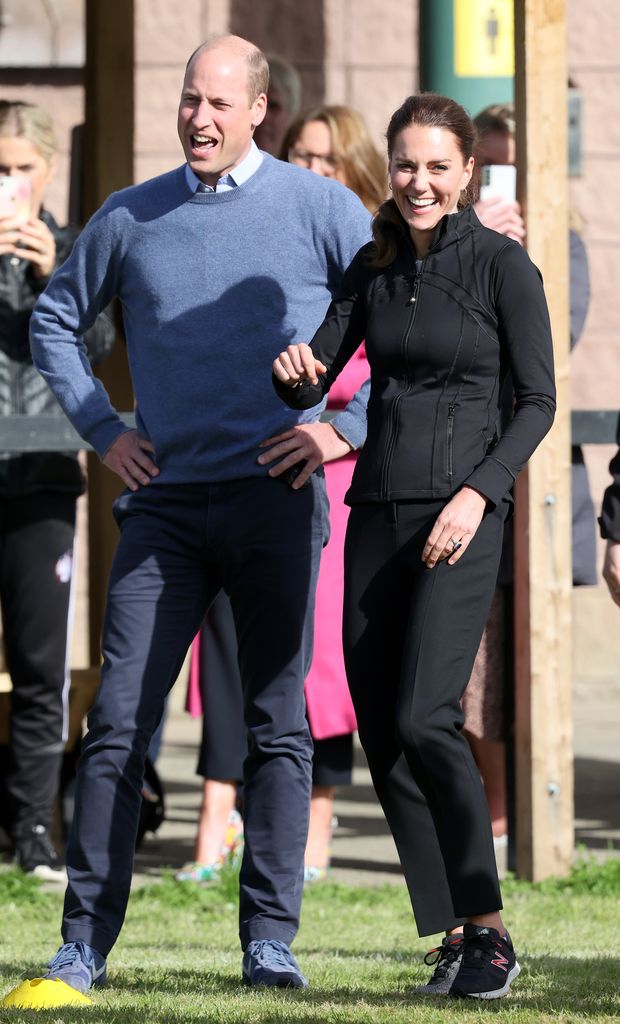 Prince William, Duke of Cambridge and Catherine, Duchess of Cambridge laugh after the Duchess kicks a rugby ball 