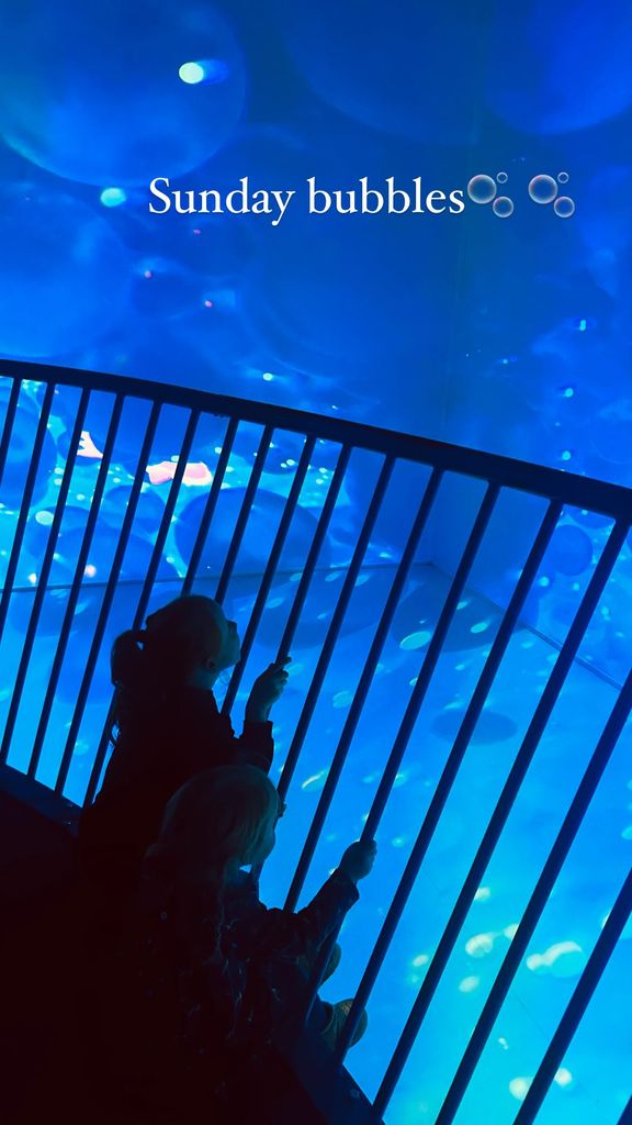 two girls staring at bubble artwork display