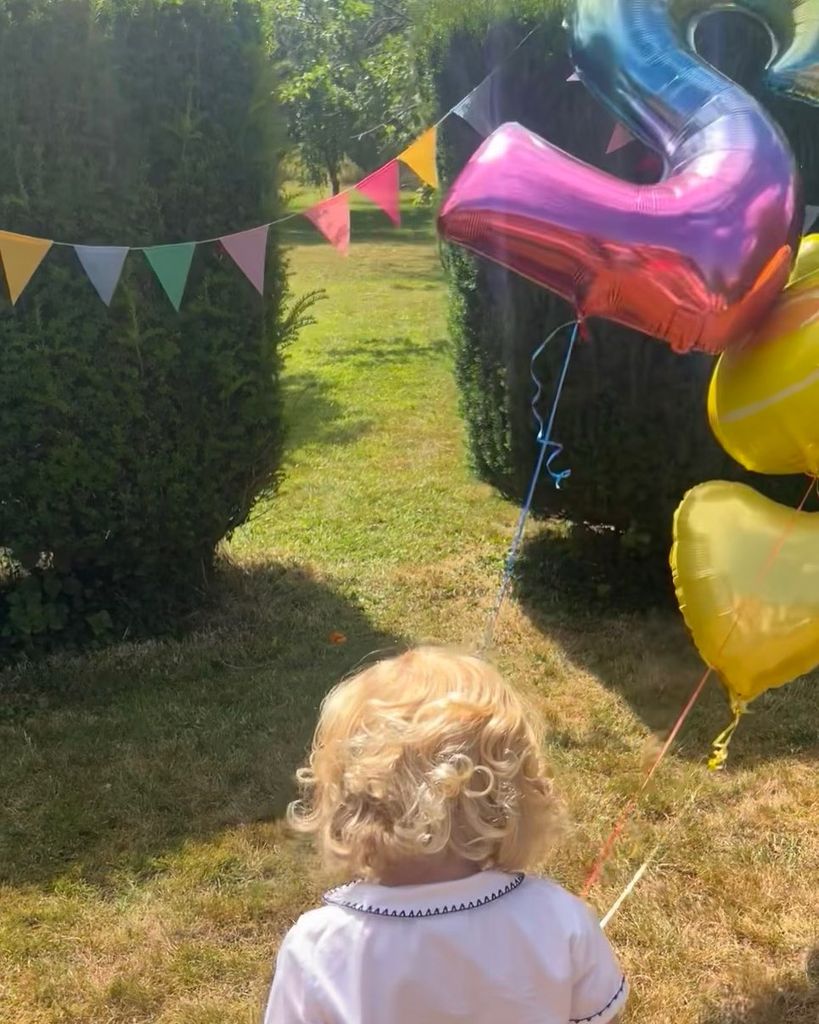 Carrie Johnson's son Frankie holding balloons in the garden
