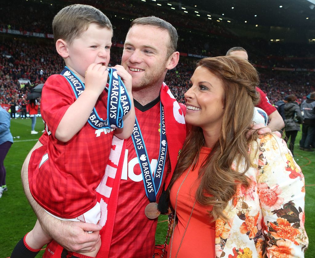 Wayne Rooney stood with Coleen Roney while holding their son Kai