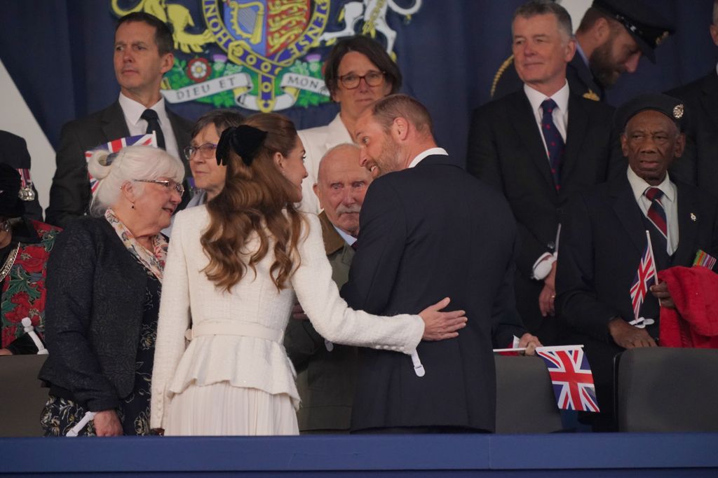 Kate putting hand on William's back and laughing