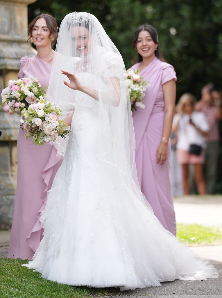 bride waves with bridesmaids in pink