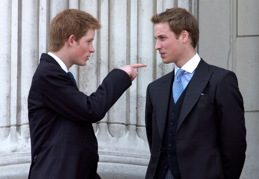 Prince Harry and Prince William in suits; Harry is pointing at William