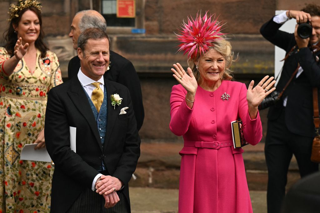 Natalia Grosvenor, Duchess of Westminster and mother of the groom, waves next to Rupert Henson, father of the bride, as Hugh Grosvenor, Duke of Westminster, and Olivia Henson leave after their wedding service 