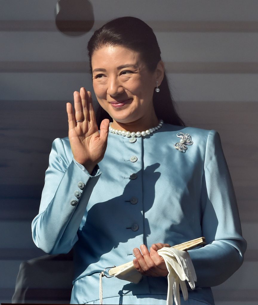 Empress Masuko in a blue dress waving