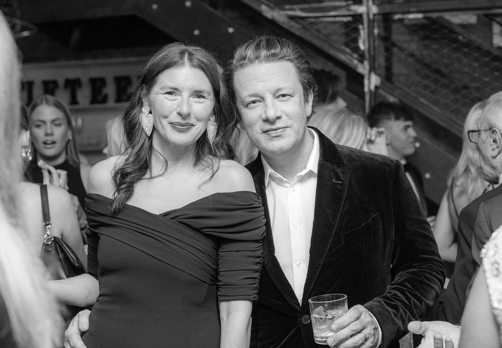 Black and white photo of Jules and Jamie Oliver dressed in fancy clothes at a party