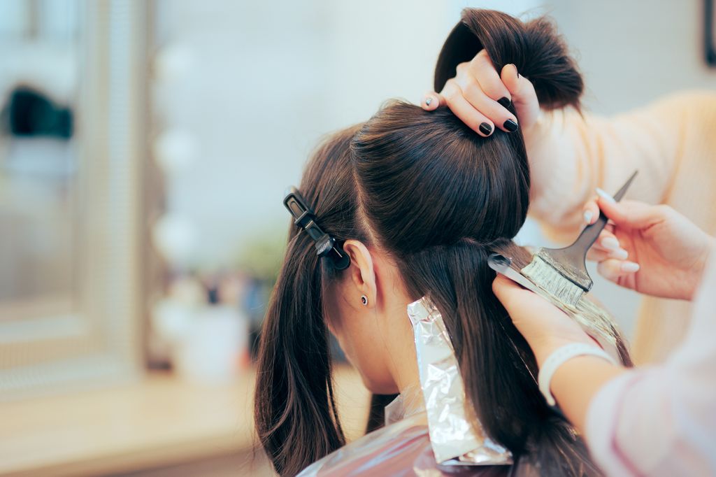 Brunette woman having her hair coloured
