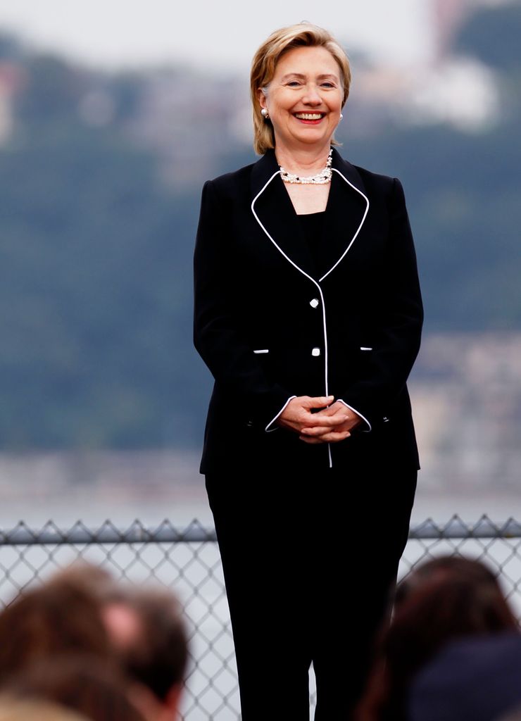 Hillary Rodham Clinton vestindo um terno preto e colar em 2009