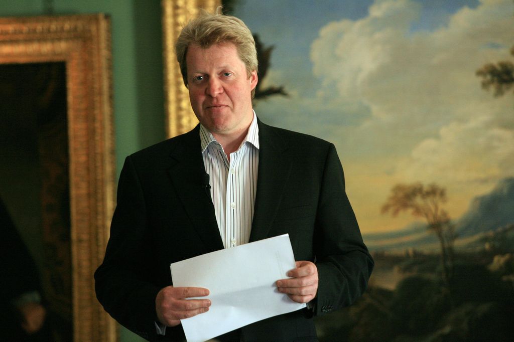 Charles Spencer in a suit in front of paintings