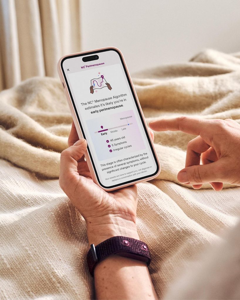 Woman wearing a tracking bracelet looking at an app