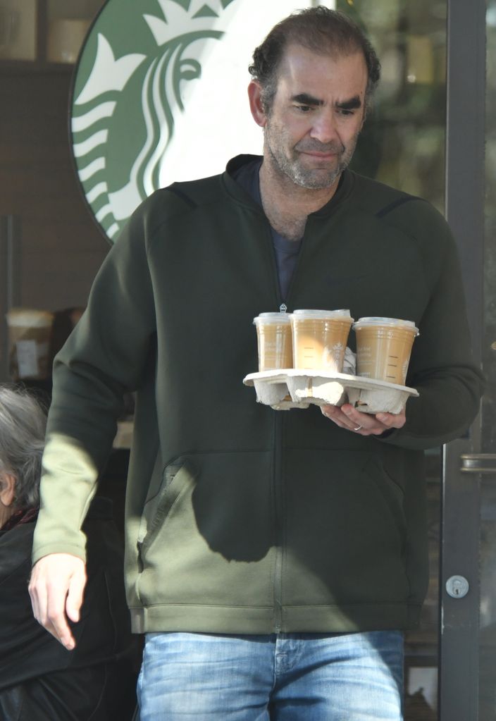 man walking holding tray of coffee 