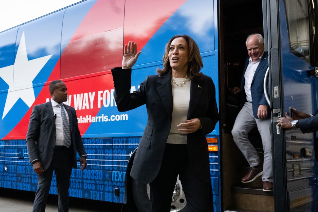 Democratic presidential candidate US Vice President Kamala Harris and her running mate, Minnesota Governor Tim Walz, disembark from their campaign bus in Savannah, Georgia, August 28, 2024, as they travel across Georgia for a 2-day campaign bus tour