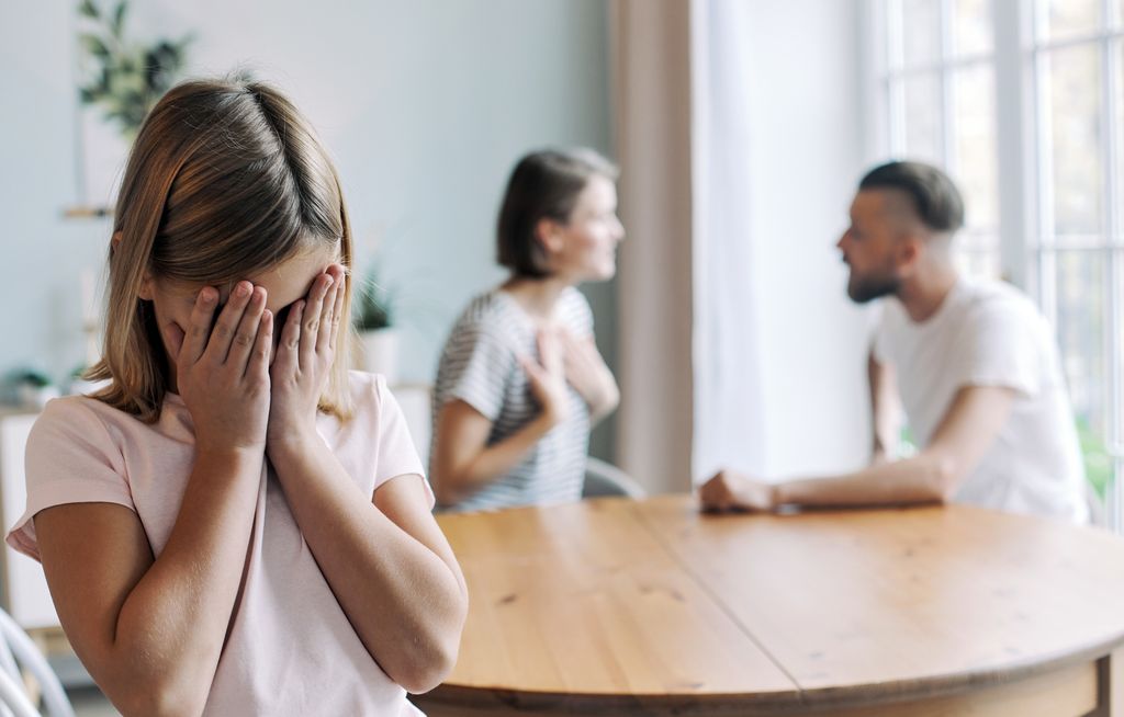 Little girl, daughter suffers from her parents fighting, quarrelling, screaming, sorting their relations at home.  Divorce, problem in family break up, bad relationships, psychological problem caused by mom and dad arguing, conflicts, impact on child concept