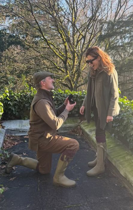 A man getting down on one knee in front of Sophie Stanbury