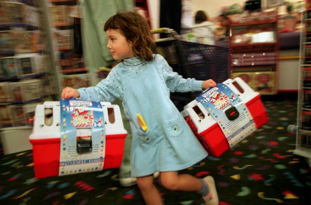 L'enfant traverse le magasin Zany Brainy avec une boîte dans chaque main.